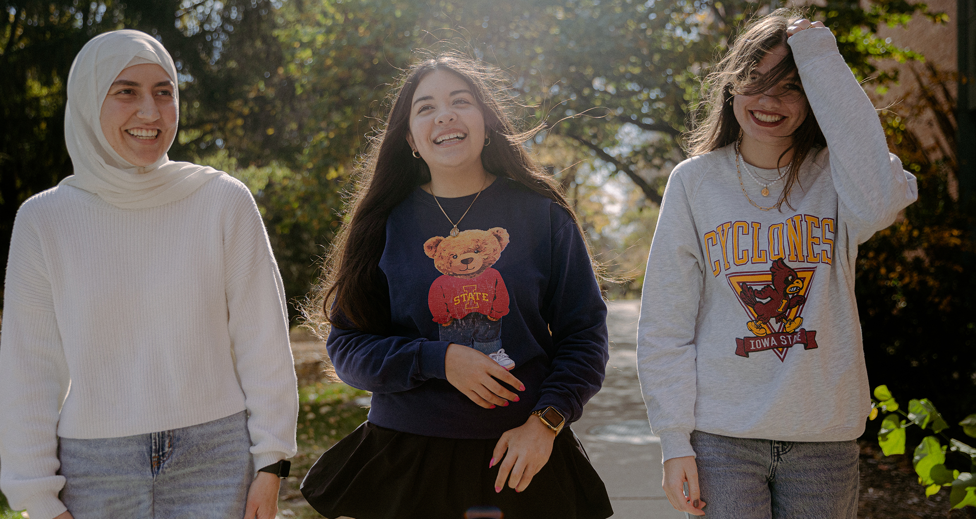 three female students walk outside Pearson Hall on the Iowa State campus