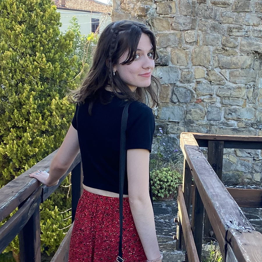 Meghan Agnew stands on a wooden pathway looking back at the camera smiling