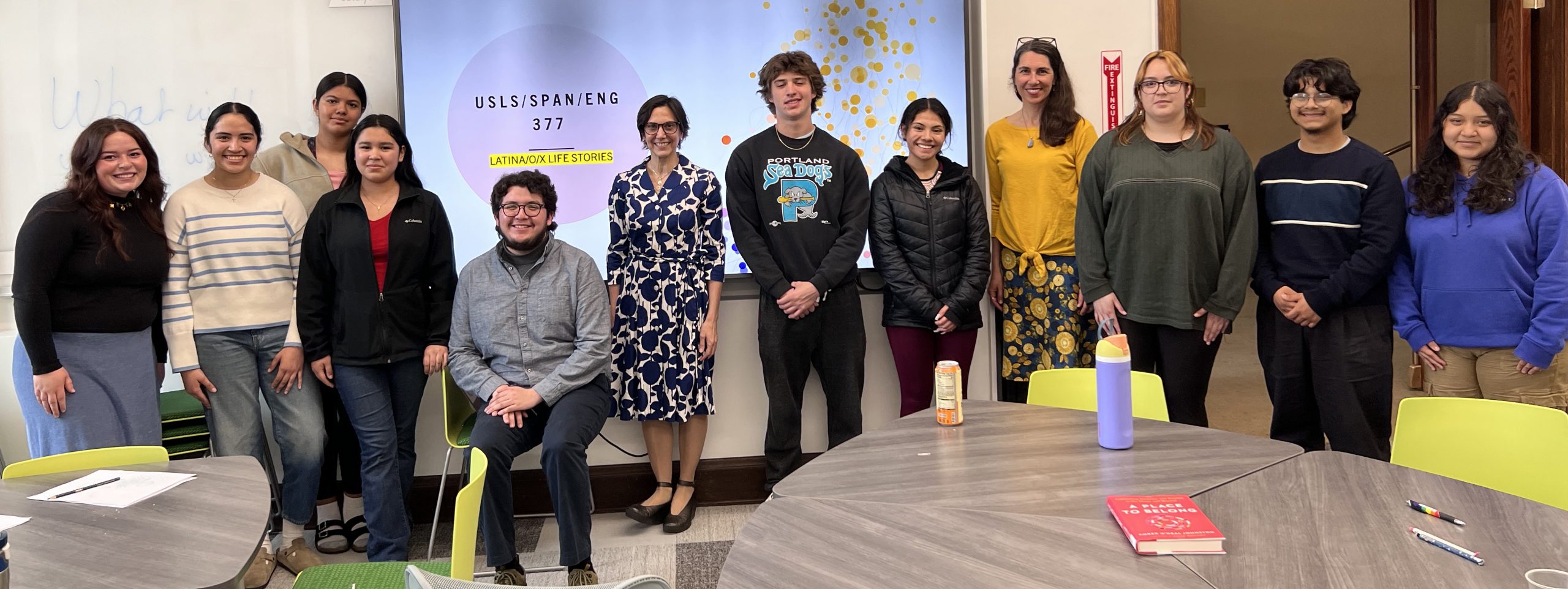 Group of students standing and smiling with instructor in a USLS/Span/ENGL 3770 class