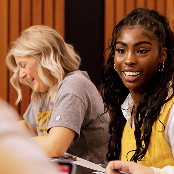 Two business majors smile while studying together