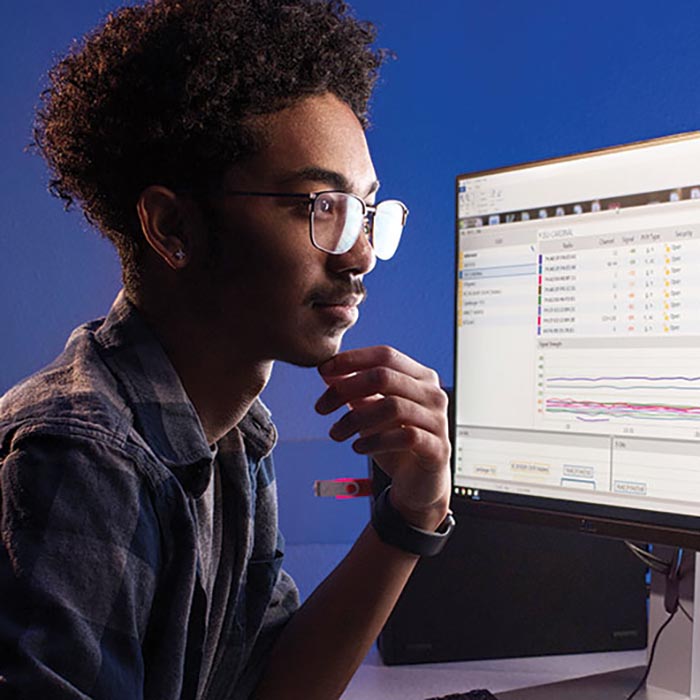 An engineering student looks over some code on a computer monitor