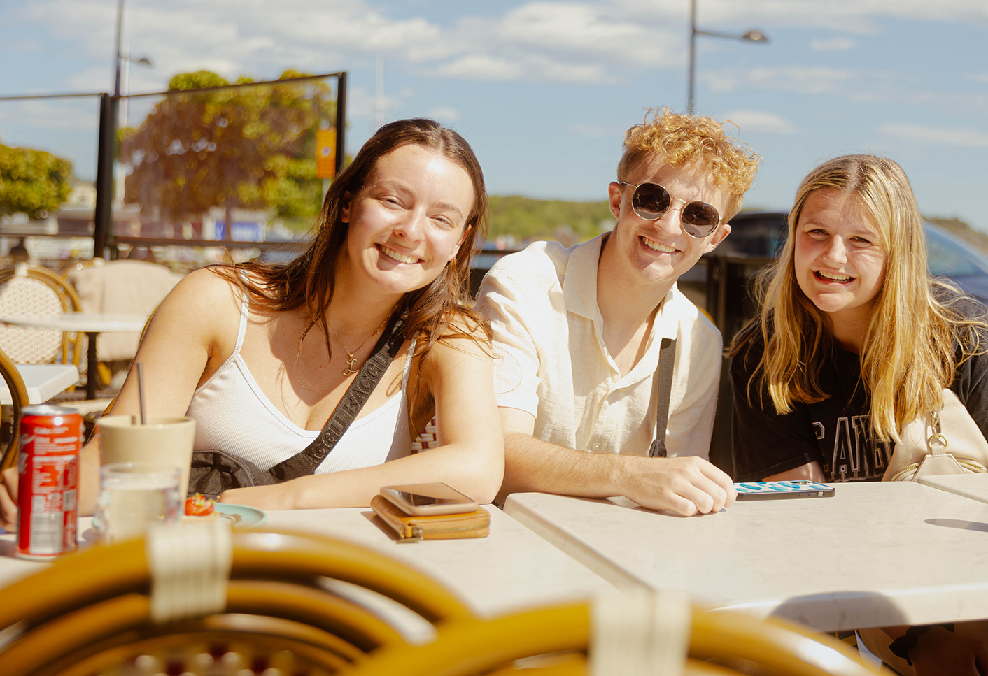 Three students sitting at a table and smiling while on a Study Abroad trip